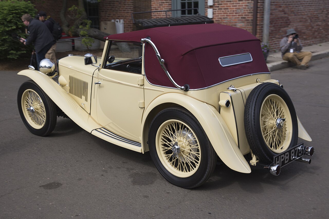 The same MG TA from the rear, showing the folding Tickford hood operated by a handle through the rear quarter panel.