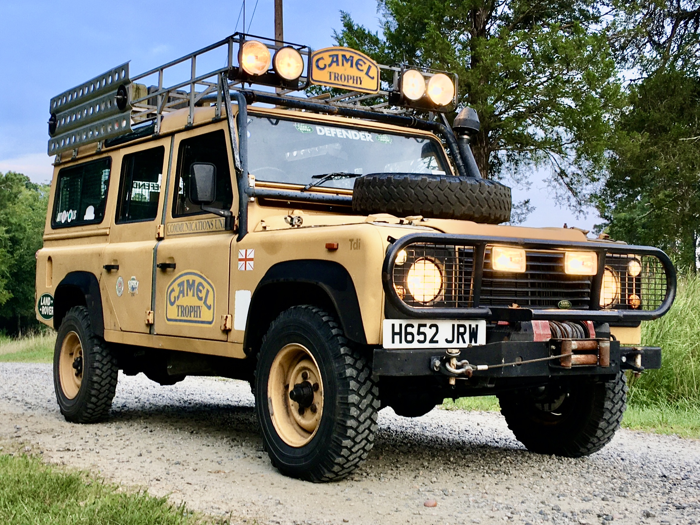 Tdi-era Defender 110 in Camel Trophy livery with roof rack, lamps and winch