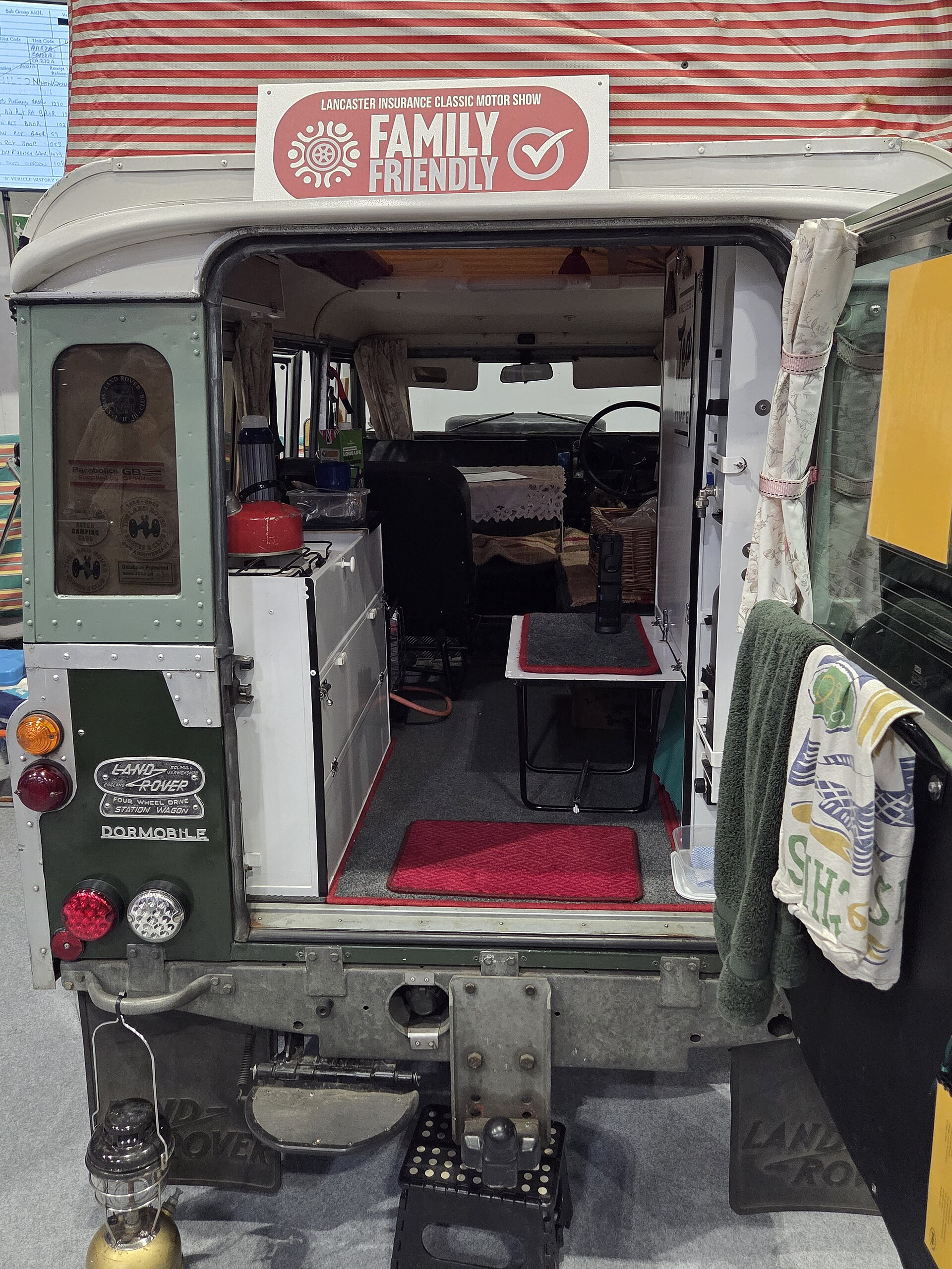 Rear view of a Land Rover Dormobile camper showing the side-hinged roof and striped fabric, Classic Motor Show, NEC Birmingham, 2025