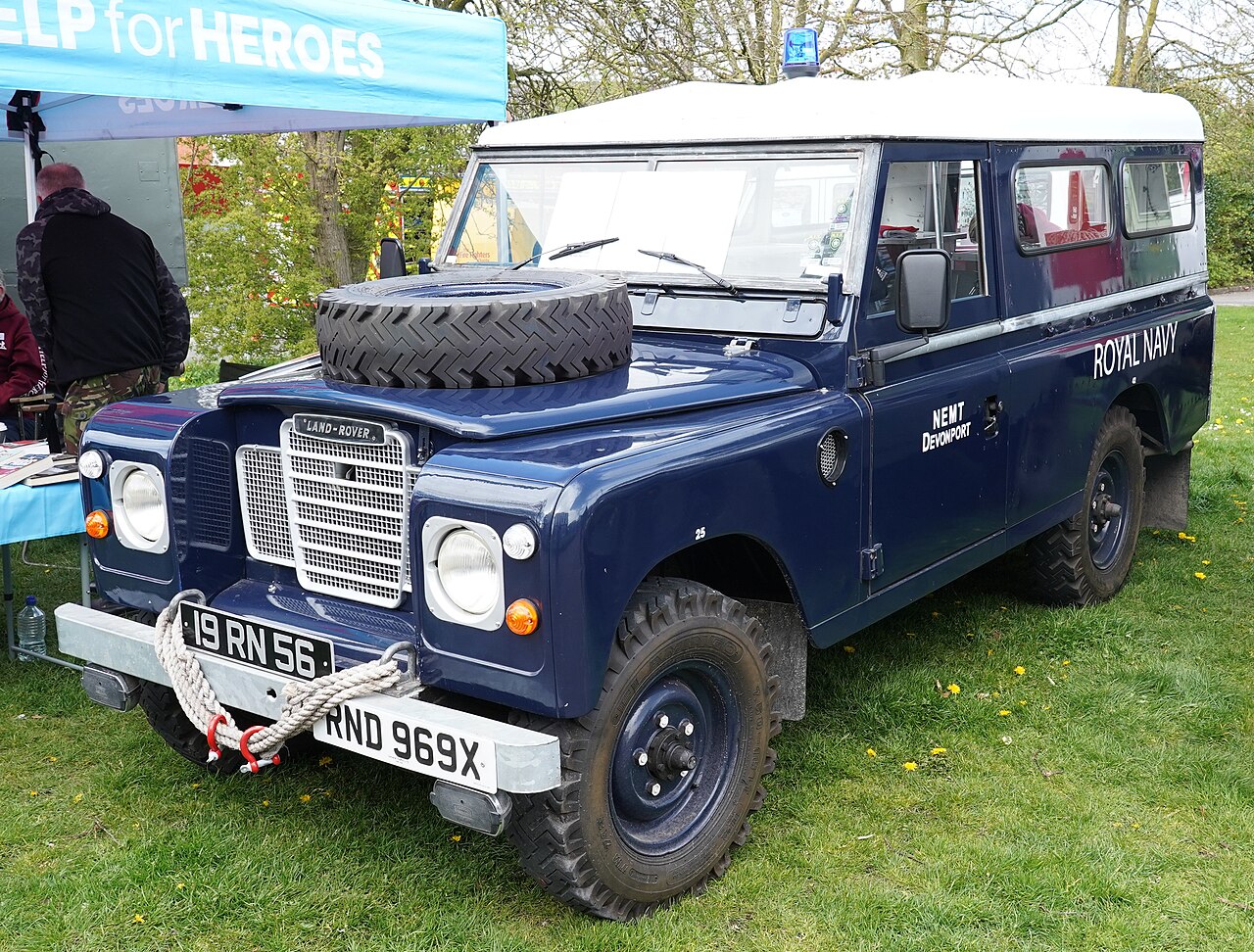 Preserved long-wheelbase Royal Navy Land Rover 19 RN 56 (NEMT Devonport) in the same gloss dark navy scheme with white roof, bonnet spare and rope-dressed bumper